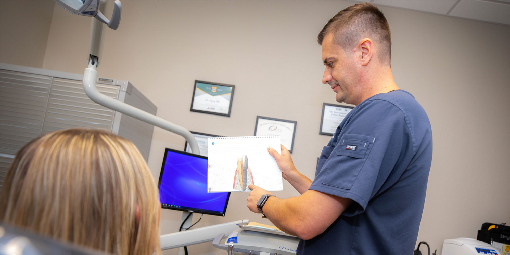 drtitov showing implant to patient during consultation