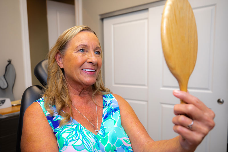 donna with mirror after smile makeover