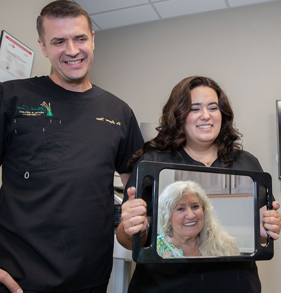 patient and doctor and staff member smiling after patient's procedure within the dental rpactice